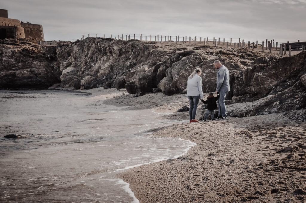 photo d'une famille sur une plage lors d'un shooting de grossesse