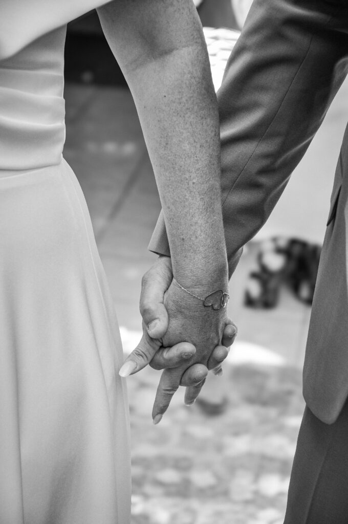 photo en noir et blanc de deux mains jointes lors d'un mariage