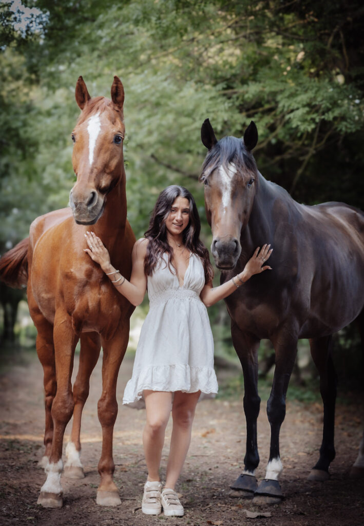 shooting photo de célia jeune femme brune en robe crème avec ces chevaux lili et liam pur sang arabe et pur sang anglais en fin de journée dans la campagne